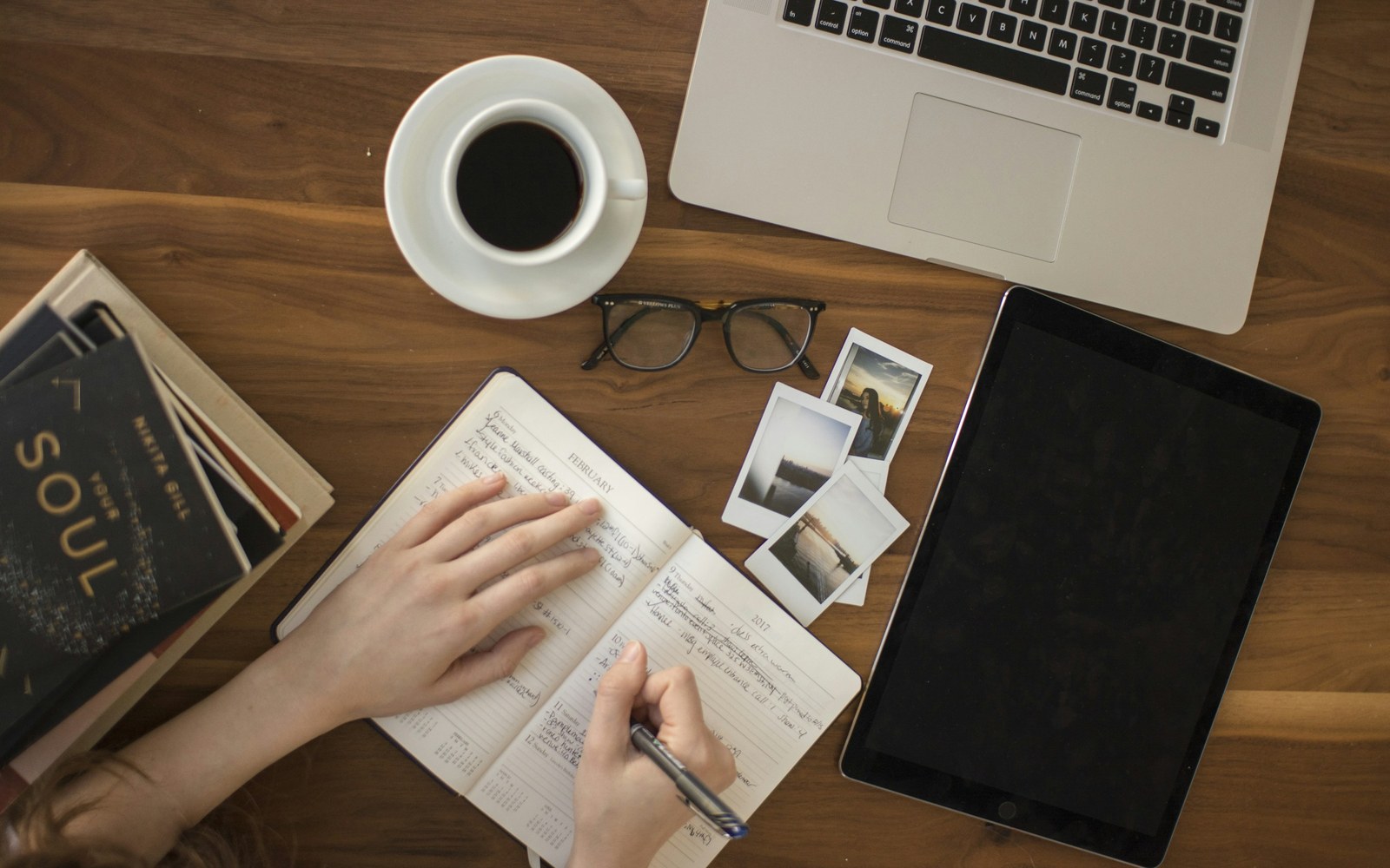 Une table de travail avec des livres, des carnets et un ordinateur