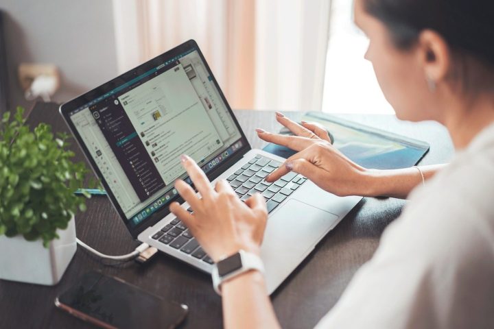 Femme qui travaille sur un ordinateur portable à son bureau à domicile