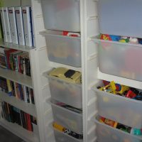 Meuble de rangement avec bacs transparents et étagères de livres