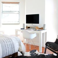 Pièce unique avec un lit, un bureau blanc et un ordinateur près de la fenêtre