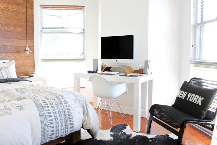 Pièce unique avec un lit, un bureau blanc et un ordinateur près de la fenêtre