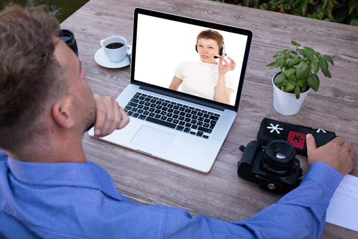 Homme qui suit un cours en visioconférence sur son ordinateur portable