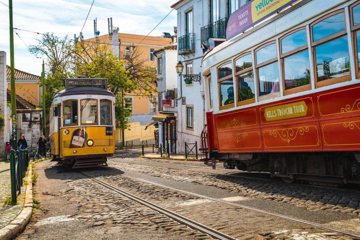 Tramway jaune et tramway rouge dans une rue pavée de Lisbonne