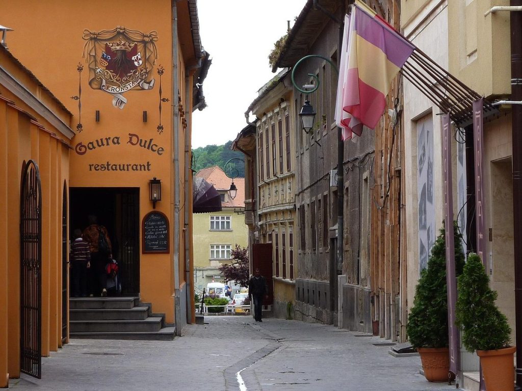Rue d'une vieille ville de Brașov, façades colorées et restaurant « Gaura Dulce »