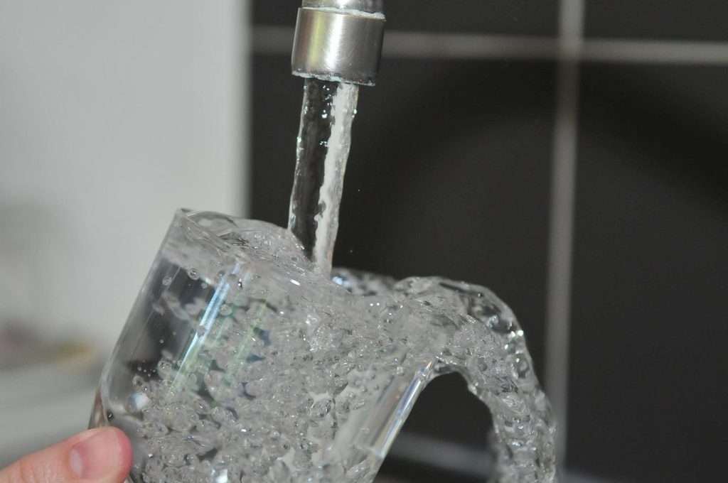 Un verre qui se remplit au robinet d'un évier
