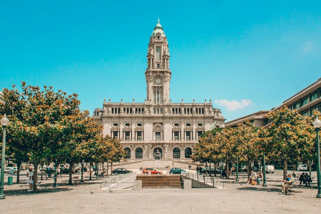 La mairie de Porto, avec sa tour et sa place plantée d'arbres, sous un ciel bleu