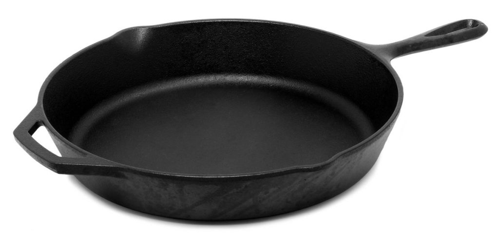Poêle en fonte noire vue de trois quarts, sur fond blanc