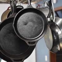 Poêles en fonte et en inox suspendues dans une cuisine
