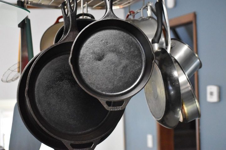 Poêles en fonte et en inox suspendues dans une cuisine
