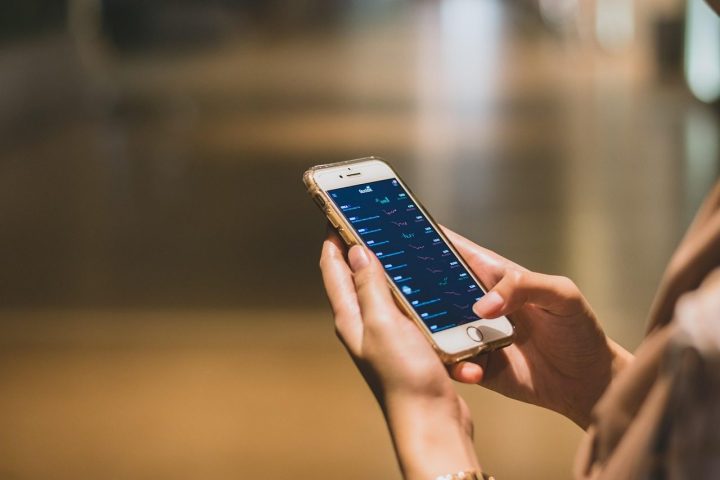 Une personne consulte une application de finance sur son smartphone